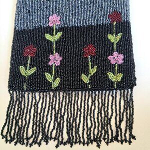 Black and silver beaded wrist bag with floral design and fringes.